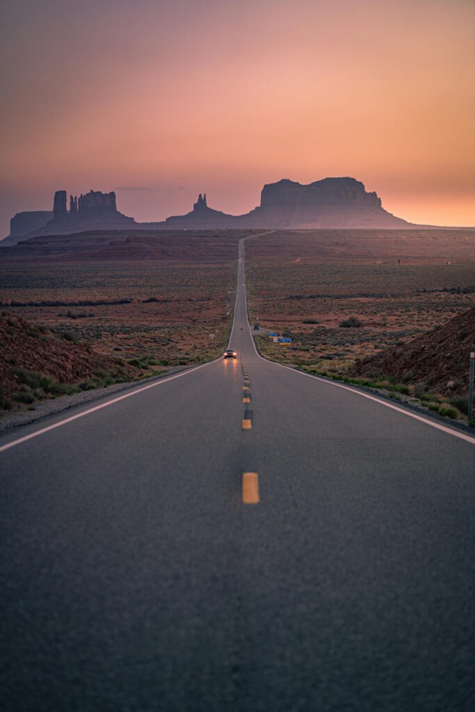 Dramatic road leading to Monument Valley with a stunning sunset sky.