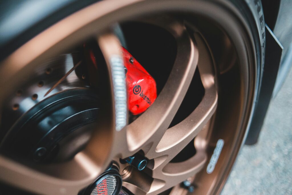Detailed close-up of a bronze car wheel showcasing a red Brembo brake caliper.